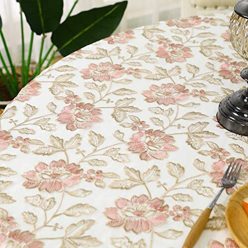 Round table with floral-patterned tablecloth and silver bowl.