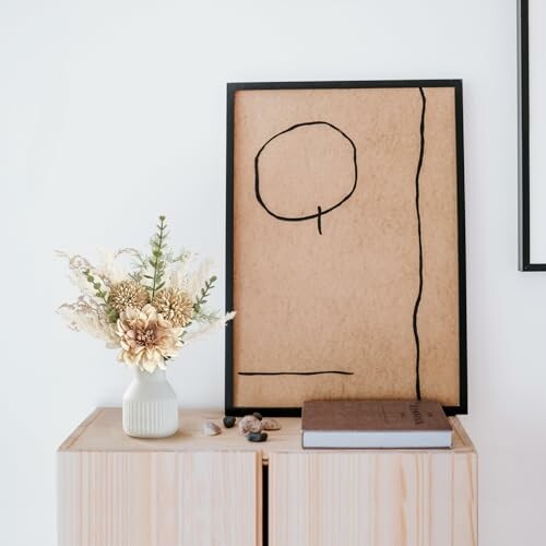 Minimalist art and vase on wooden cabinet