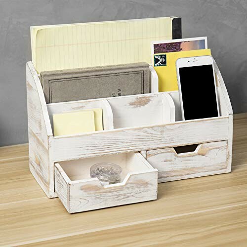 Wooden desk organizer with compartments and drawers holding papers, notebooks, and a smartphone.