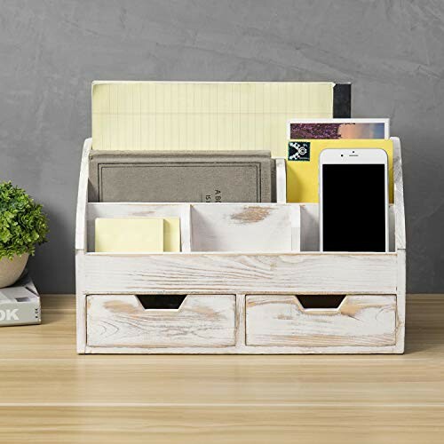 Wooden desk organizer with compartments holding stationery and a smartphone.