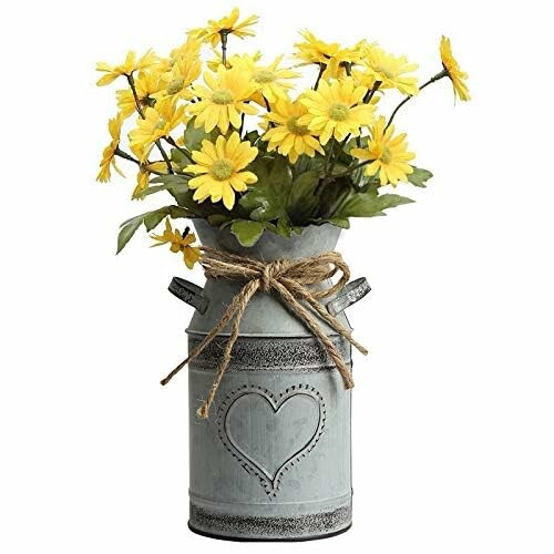 Yellow flowers in a metal vase with a heart design and twine bow